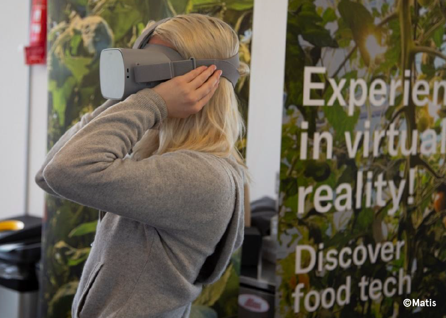 Zara Larsson in grey hoodie trying grey visor for virtual reality